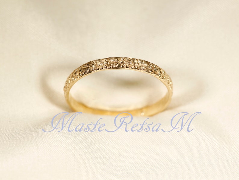 Puede incluir: Un anillo de banda de oro con un delicado dise&ntilde;o floral.