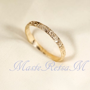 Puede incluir: Un anillo de banda de oro simple con un delicado dise&ntilde;o floral grabado alrededor de toda la banda.