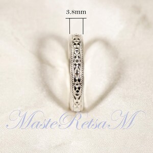 May include: Close-up of a silver ring with an intricate floral design. The ring's width is 3.8mm. The ring is displayed on a white surface. The text "MasteRetsa M" is visible in the image.
