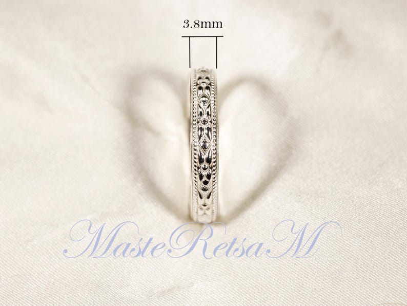 May include: Close-up of a silver ring with an intricate floral design. The ring's width is 3.8mm. The ring is displayed on a white surface. The text "MasteRetsa M" is visible in the image.