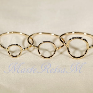 Puede incluir: Tres anillos de oro con un diseño circular. Los anillos son de diferentes tamaños.