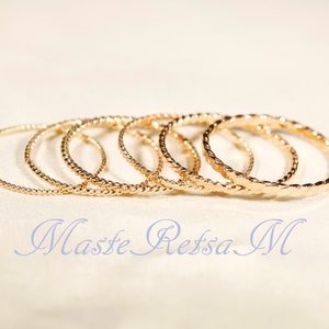 May include: Set of six gold-toned bangle bracelets with a twisted design.