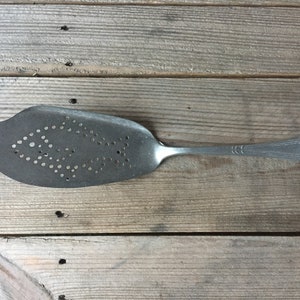Stary niemiecki aluminiowy serwer do żywności, łopatka do ciasta, metal perforowany, obrazek ryby, dekoracja ryby.