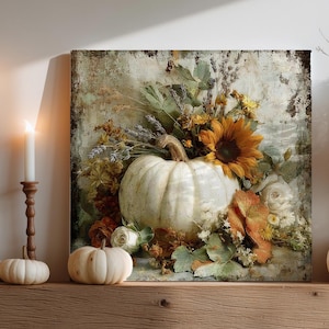 May include: A square canvas print featuring a white pumpkin, sunflowers, and fall foliage. The print is displayed above a wooden mantel, alongside candles, vases, and decorative pumpkins. The overall theme is autumn and harvest.
