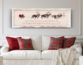 May include: A rectangular wall sign with a distressed white frame featuring a graphic of Santa Claus in a sleigh pulled by reindeer. The text reads: MAY YOU NEVER BE TOO GROWN UP TO SEARCH THE SKIES ON Christmas Eve in red and black lettering.