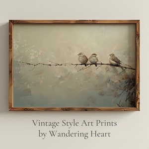May include: A framed vintage style art print featuring three brown birds perched on a branch against a soft, muted background of blue, green, and white. The birds are facing to the right and are in a row. The print is framed in a rustic brown wood frame. The text below the image reads 'Vintage Style Art Prints by Wandering Heart'.