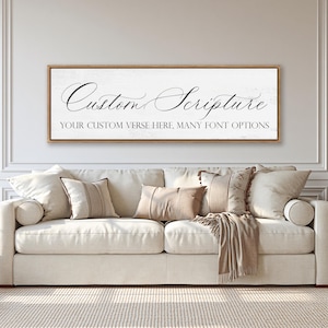 May include: A rectangular wall sign with a light wood frame featuring a white background and black text. The sign displays the words Custom Scripture in a large cursive font, followed by the text YOUR CUSTOM VERSE HERE, MANY FONT OPTIONS.