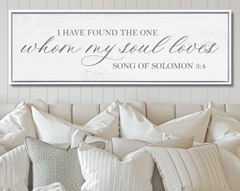 Puede incluir: Un letrero de pared rectangular con un fondo blanco de aspecto de madera desgastada y un marco gris fino. El texto dice "I HAVE FOUND THE ONE whom my soul loves SONG OF SOLOMON 3:4" en una combinación de fuentes serif y script gris oscuro.