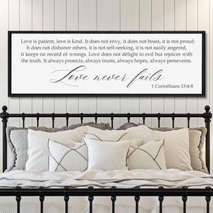 May include: A rectangular wall sign with a black frame featuring white background and black text. The text reads: Love is patient, love is kind. It does not envy, it does not boast, it is not proud. It does not dishonor others, it is not self-seeking, it is not easily angered, it keeps no record of wrongs. Love does not delight in evil but rejoices with the truth. It always protects, always trusts, always hopes, always perseveres. Love never fails 1 Corinthians 13:4-8.