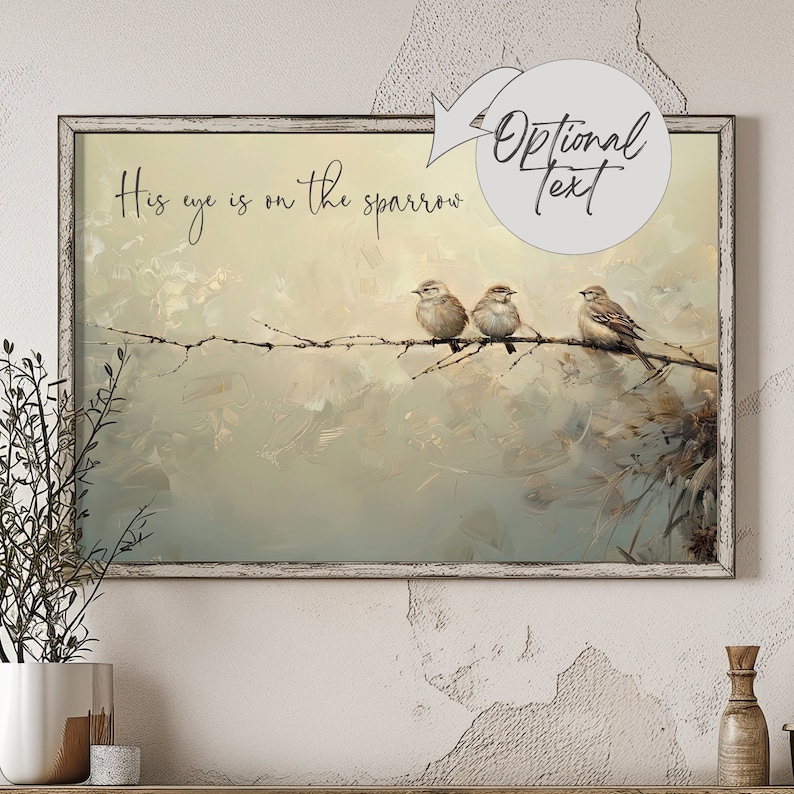 May include: A framed painting of three sparrows perched on a branch. The background is a soft, muted green and blue with a brushstroke effect. The text 'His eye is on the sparrow' is written in black at the top of the painting.