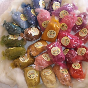 May include: Assortment of colourful wool roving in clear plastic bags with labels that say "Fiber Tale Farm".