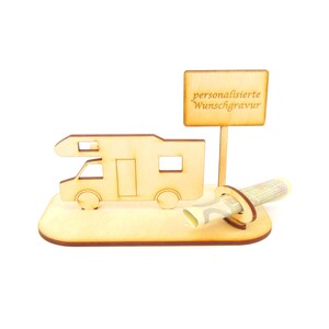 May include: A wooden camper van money box with a sign that reads "personalised Wunschgravur". The money box is designed to hold a rolled-up bill.