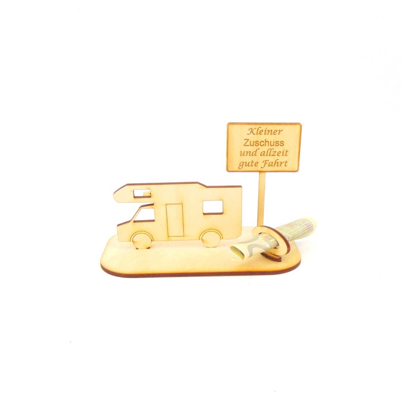 May include: Wooden camper van money holder with a sign that reads "Kleiner Zuschuss und allzeit gute Fahrt" which translates to "Small contribution and always good journey".
