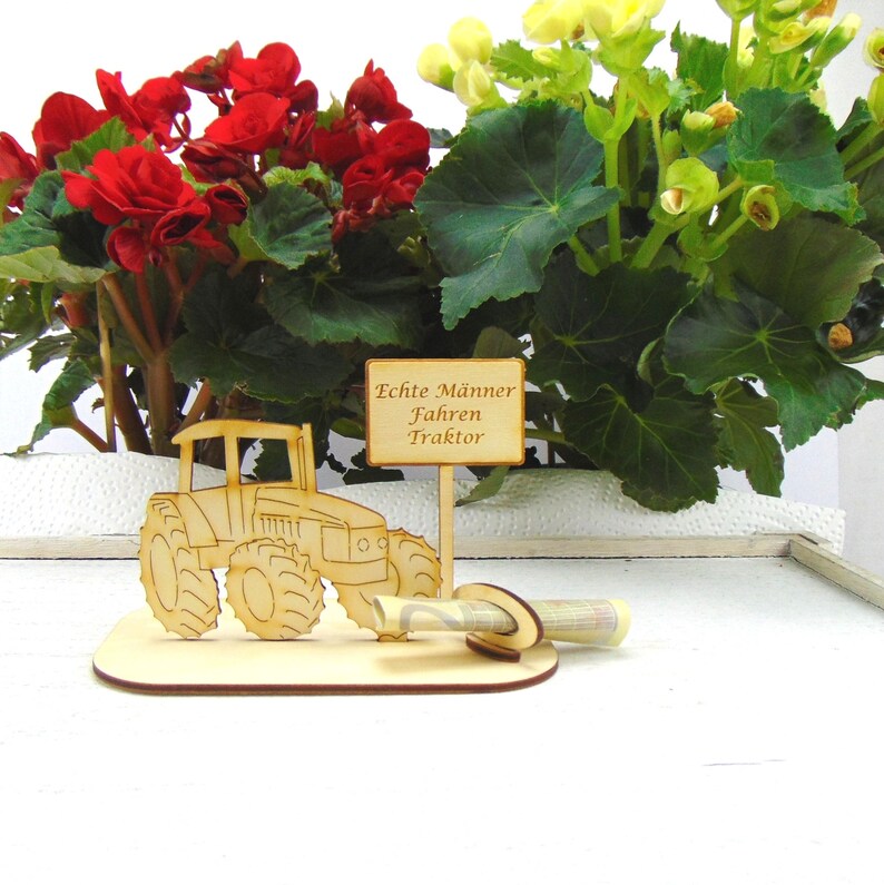 May include: Wooden tractor money holder with a sign that reads "Echte M&auml;nner Fahren Traktor" (Real men drive tractors).