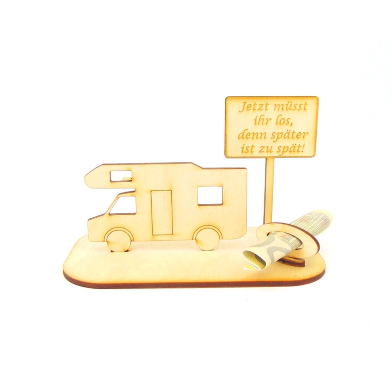 May include: Wooden camper van money holder with a sign that reads "Jetzt m&uuml;sst ihr los, denn sp&auml;ter ist zu sp&auml;t!"  The sign is attached to a wooden stick. A rolled up bill of money is placed in the holder.