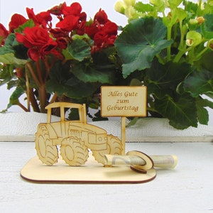 May include: Wooden tractor money holder with a sign that reads "Alles Gute zum Geburtstag" (Happy Birthday). The holder is decorated with a tractor and a place to put money.