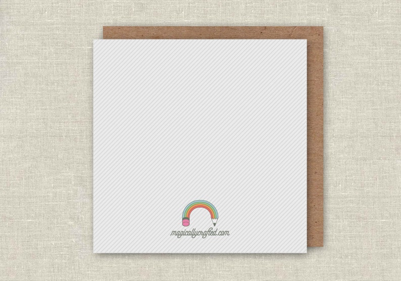 May include: Blank white card with a rainbow and pencil design. The text "magicallycrafted.com" is printed below the design.