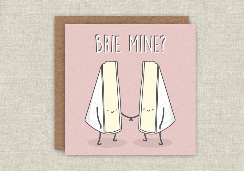 May include: A pink card with the text "Brie Mine?" in black. Two cartoon brie cheese wedges are holding hands.