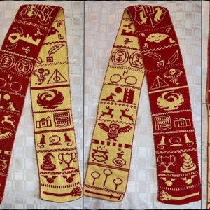 Puede incluir: Una bufanda de punto roja y amarilla con temática de Harry Potter. La bufanda presenta varios símbolos del universo de Harry Potter, incluyendo una snitch dorada, un escudo de la casa de Hogwarts y un par de gafas.