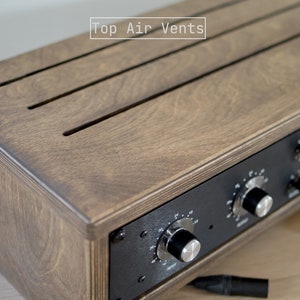 May include: A wooden box with a black front panel and three knobs. The top of the box has three air vents and the text "Top Air Vents" is printed on the top.