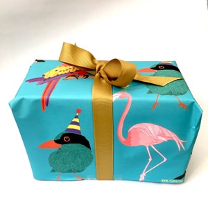 May include: A blue gift box with a gold ribbon and a colourful bird and flamingo design. The box has the text "www.frankieandjoy.com" on the bottom.