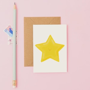 Peut inclure: Une carte de vœux avec une illustration d'étoile jaune souriante. La carte est sur fond rose avec une enveloppe marron, un crayon vert clair et des timbres.
