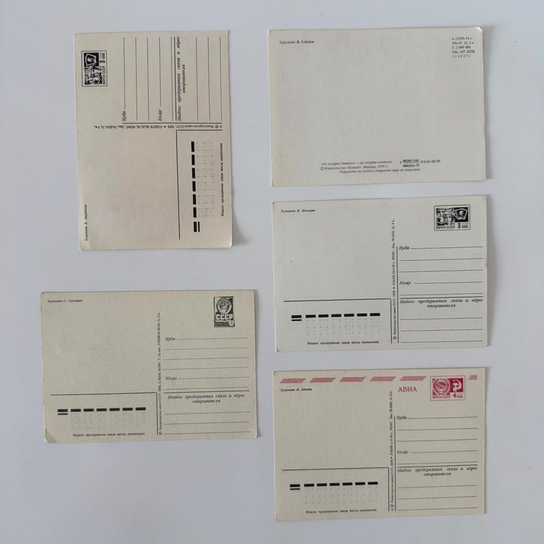 May include: Five vintage postcards from the USSR, each featuring a cream-colored paper back with printed lines for addresses, postal codes, and stamps. The cards include Cyrillic text, various postage markings, and specific artist credits.