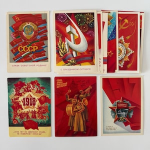 Könnte beinhalten: Eine Sammlung von sechs rechteckigen Postkarten mit sowjetisch inspirierten Illustrationen in Rot, Gold und Grün. Die Motive zeigen Hammer und Sichel, Militärorden, marschierende Musiker und das Jahr 1918, jeweils mit kyrillischem Text bedruckt.