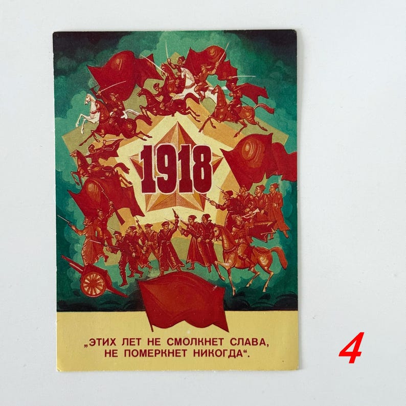 May include: A rectangular postcard featuring a central gold star with the text 1918, surrounded by red illustrations of soldiers on horseback and on foot with red flags. The bottom section is cream-colored with Russian text in red lettering.