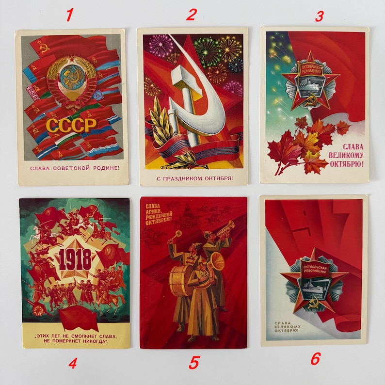 May include: A collection of six rectangular vintage postcards featuring Soviet-themed illustrations. Each card displays red banners, gold stars, hammers, sickles, and Cyrillic text. The designs include military motifs, fireworks, and historical dates.