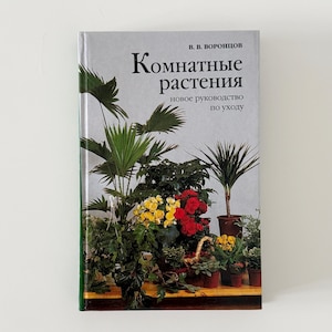May include: A hardcover book titled "Комнатные растения" (Indoor Plants) with a cover featuring various potted plants, including palms and flowering plants. The book's title is in Russian, with the author's name at the top.