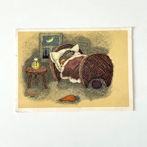 May include: Vintage illustration of a rabbit sleeping in a bed. The bed has a brown frame and a burgundy blanket. A small table with a yellow alarm clock sits beside the bed. A carrot lies on the floor.
