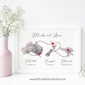 May include: A watercolor print of a map of Australia and New Zealand with a dashed line connecting three red hearts. The text "Mendy and Aaron" is at the top of the print. The text "First Date 31 October 2014", "Engaged 15 April 2016", and "Married 26 September 2017" is below the map. The text "www.AphroditeStudio.etsy.com" is at the bottom of the print.