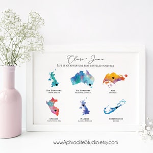 May include: A watercolor print with the names Claire and Jamie and the text "Life is an adventure best traveled together". The print features watercolor maps of different locations with black hearts marking the locations. The locations are labeled with the text "Her Hometown", "His Hometown", "Met", "Engaged", "Married", and "Honeymooned".