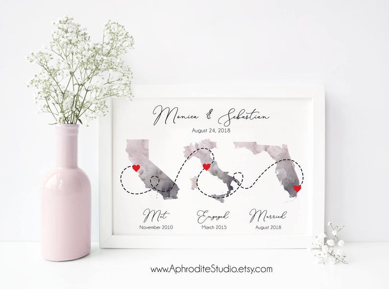 May include: A watercolor print with a map of California, Italy, and Florida. The map shows the locations where a couple met, got engaged, and married. The text reads "Monica & Sebastian, August 24, 2018, Met, November 2010, Engaged, March 2015, Married, August 2018, www.AphroditeStudio.etsy.com".