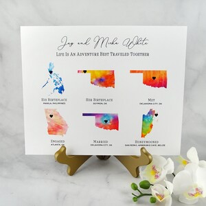 May include: A watercolor map print with the names Jay and Micha White and the text "Life is an adventure best traveled together". The map shows their birthplaces, where they met, got engaged, married, and honeymooned.