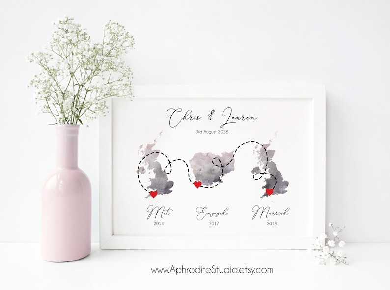 May include: A watercolor map of the United Kingdom with a dotted line showing a journey from "Met" in 2014 to "Engaged" in 2017 to "Married" in 2018. The map is in shades of gray with red hearts marking each location. The text "Chris & Lauren 3rd August 2018" is at the top of the map.