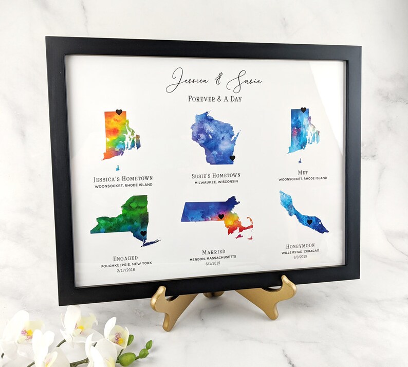 May include: A watercolor print of a couple's love story, featuring maps of their hometowns, where they met, got engaged, married, and honeymooned. The print includes the names Jessica and Susie, and the text "Forever & A Day".