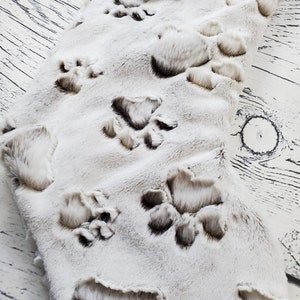 May include: White faux fur stocking with brown paw prints. The stocking has the name "Rex" on a wooden tag.