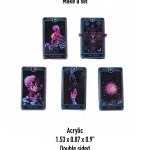 May include: Set of five double-sided acrylic tarot card charms featuring The Lovers, The Devil, The Fool, The Moon, and The Sun. Each charm is 1.53 inches by 0.87 inches by 0.9 inches.