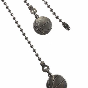 May include: Two silver chain pulls with basketball-shaped ends. The chains are made of small, round beads.