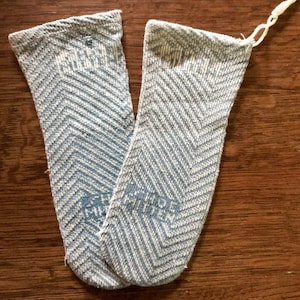 May include: A pair of blue and white chevron patterned socks. The socks are folded together and have a white string attached to one of the socks.