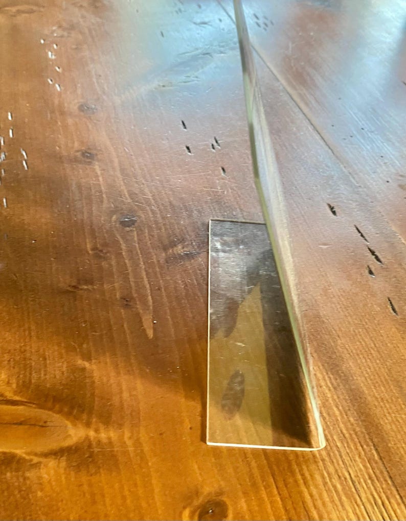 May include: A white ceramic mug with a black handle and the text "But First, Coffee" in a bold, black font. The mug is set against a blurred background, suggesting a cozy setting.