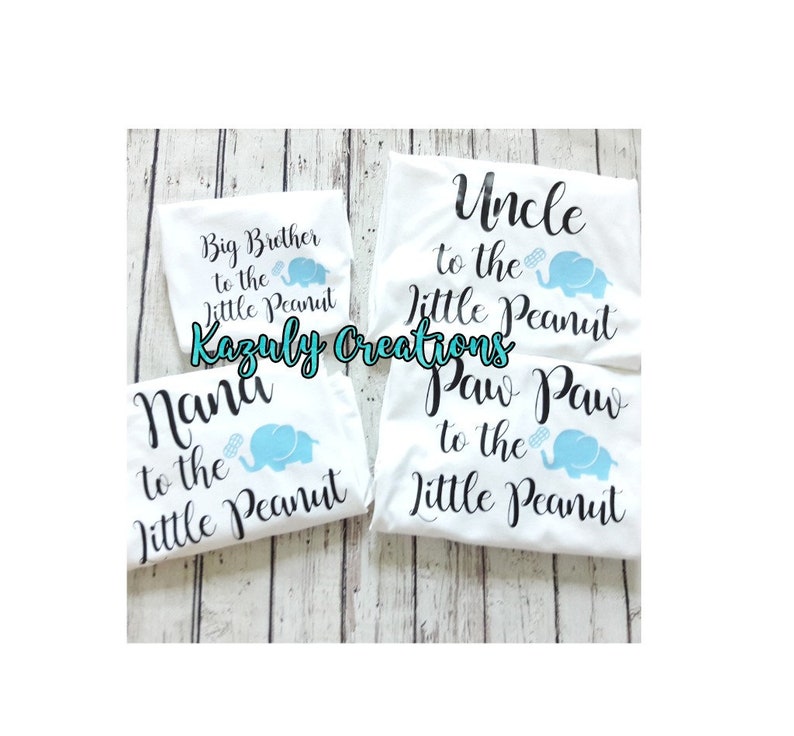 May include: Four white t-shirts with black text and blue elephant graphics. The shirts say "Big Brother to the Little Peanut", "Uncle to the Little Peanut", "Nana to the Little Peanut", and "Paw Paw to the Little Peanut".
