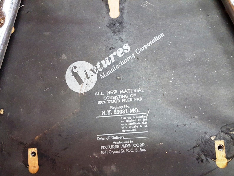 Może przedstawiać: Czarno-biała etykieta z tekstem "Fixtures Manufacturing Corporation" i "All New Material Consisting of 100% Wood Fiber Pad" z numerem rejestracyjnym "N.Y. 23031 MO."