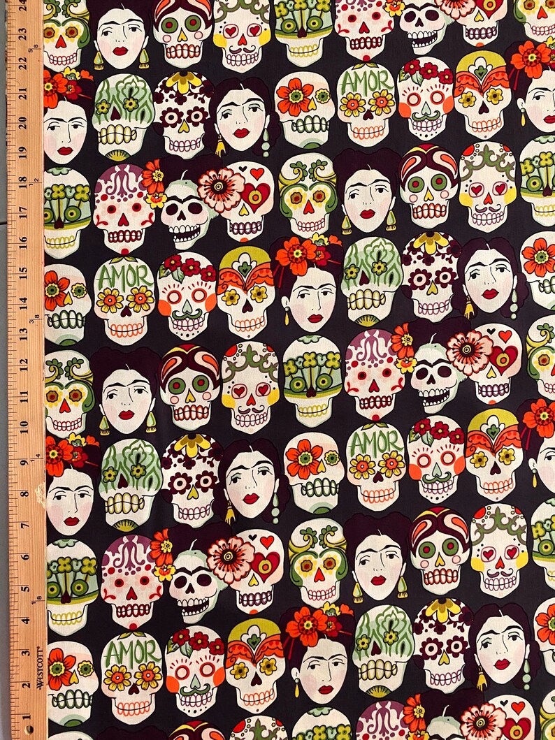 Puede incluir: Una tela negra con un patr&oacute;n repetido de calaveras de az&uacute;car coloridas y detalles florales. Las calaveras tienen varios dise&ntilde;os, incluyendo corazones, flores y la palabra "AMOR".