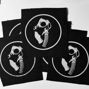 May include: Five black fabric patches with a white circle and a white gas mask design inside the circle.