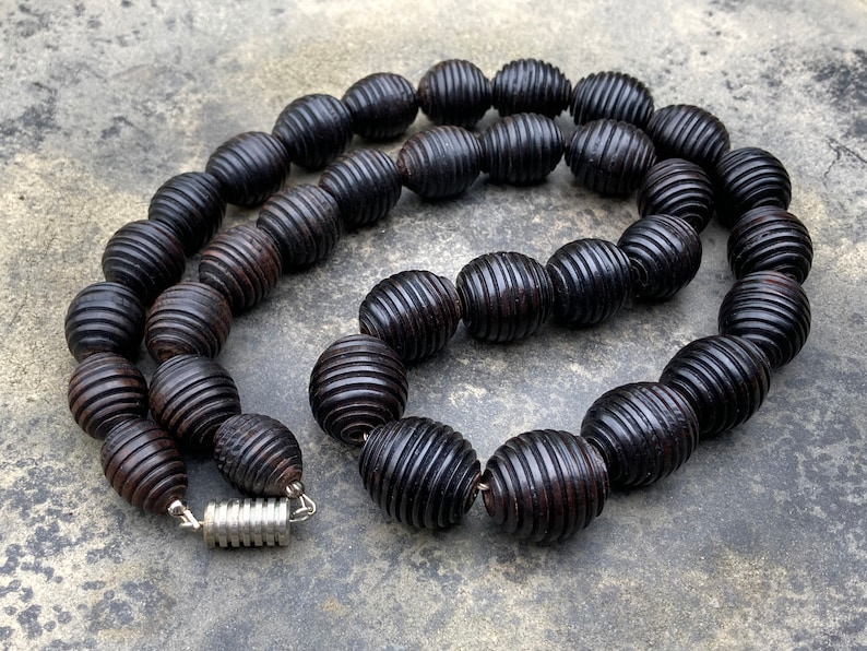 Modern. Elegant Graduated necklace of blackened wooden beads with carved grooves