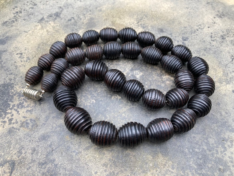 Modern. Elegant Graduated necklace of blackened wooden beads with carved grooves