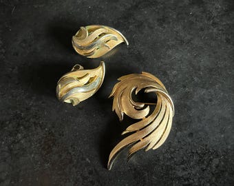 Vintage Crown Trifari demi parure set of earrings and brooch in gold tone metal.